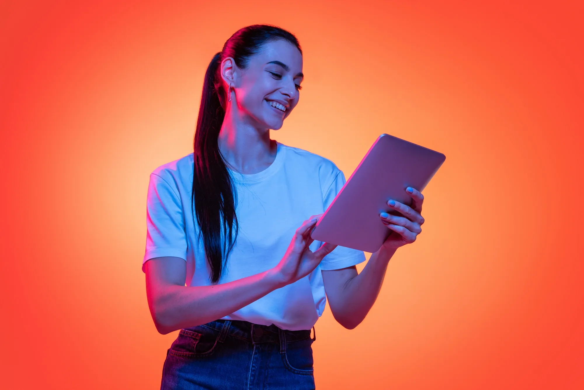 A woman smiling while reading her SOURCECODED daily briefing on a tablet, lit in orange